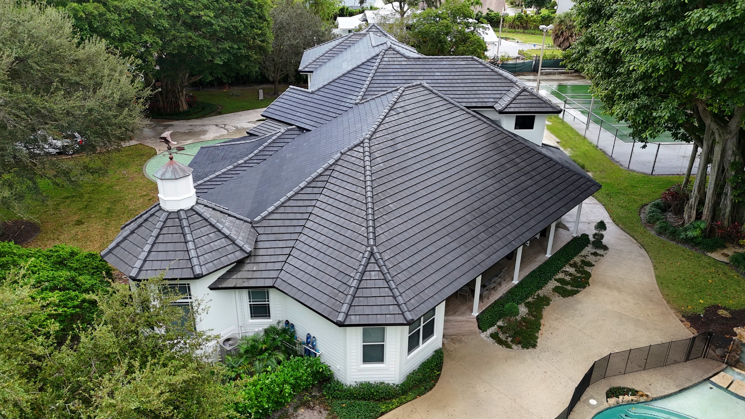 Aerial view of a premium residence with architecturally integrated solar roof tiles, indistinguishable from traditional roofing